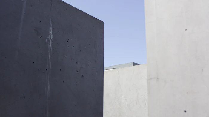 Volume de concreto escuro erguido contra o céu, visto de baixo