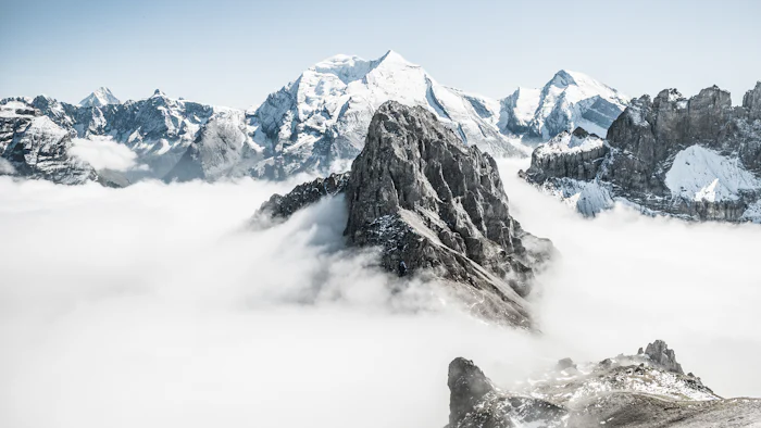 Picos de montanha emergindo acima de um mar de nuvens
